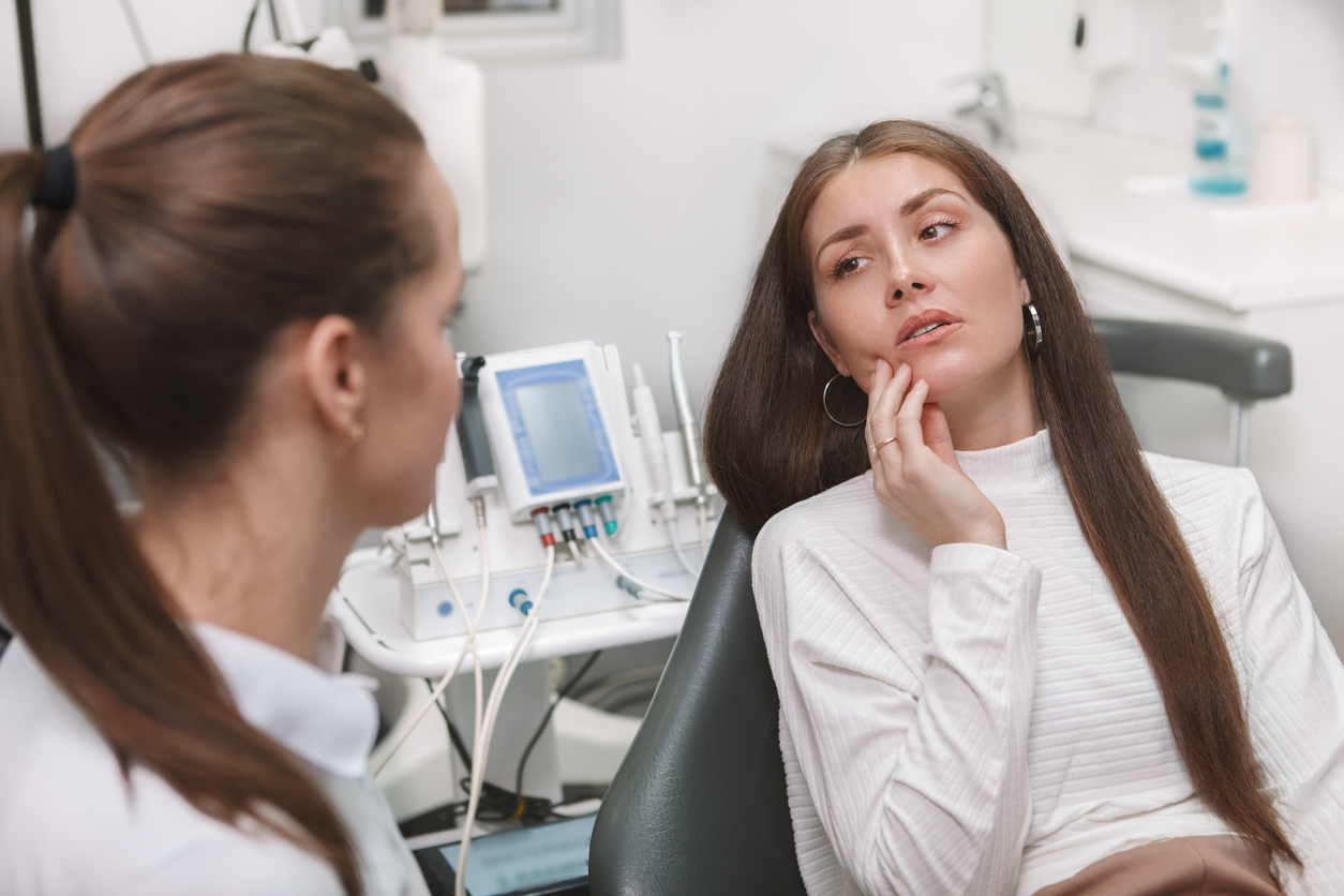 Trillum Dental - Young woman with toothache at dentist visit